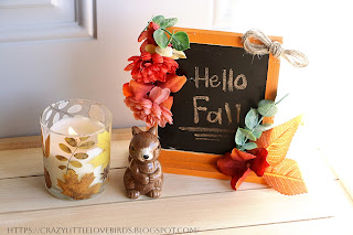 Painted framed chalkboard displayed near candle in glass jar
